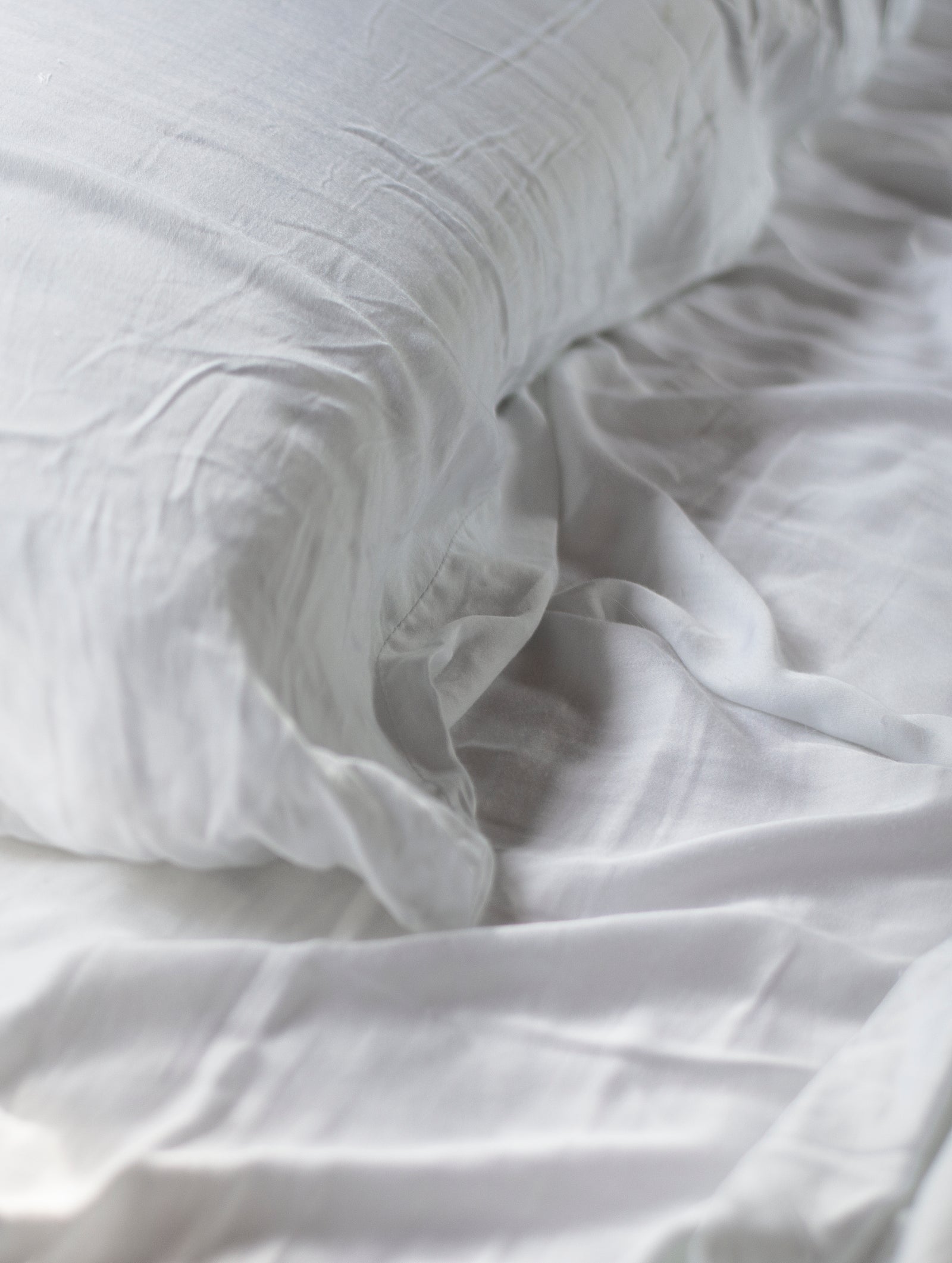 White bed sheets and pillow, close-up of the cloth