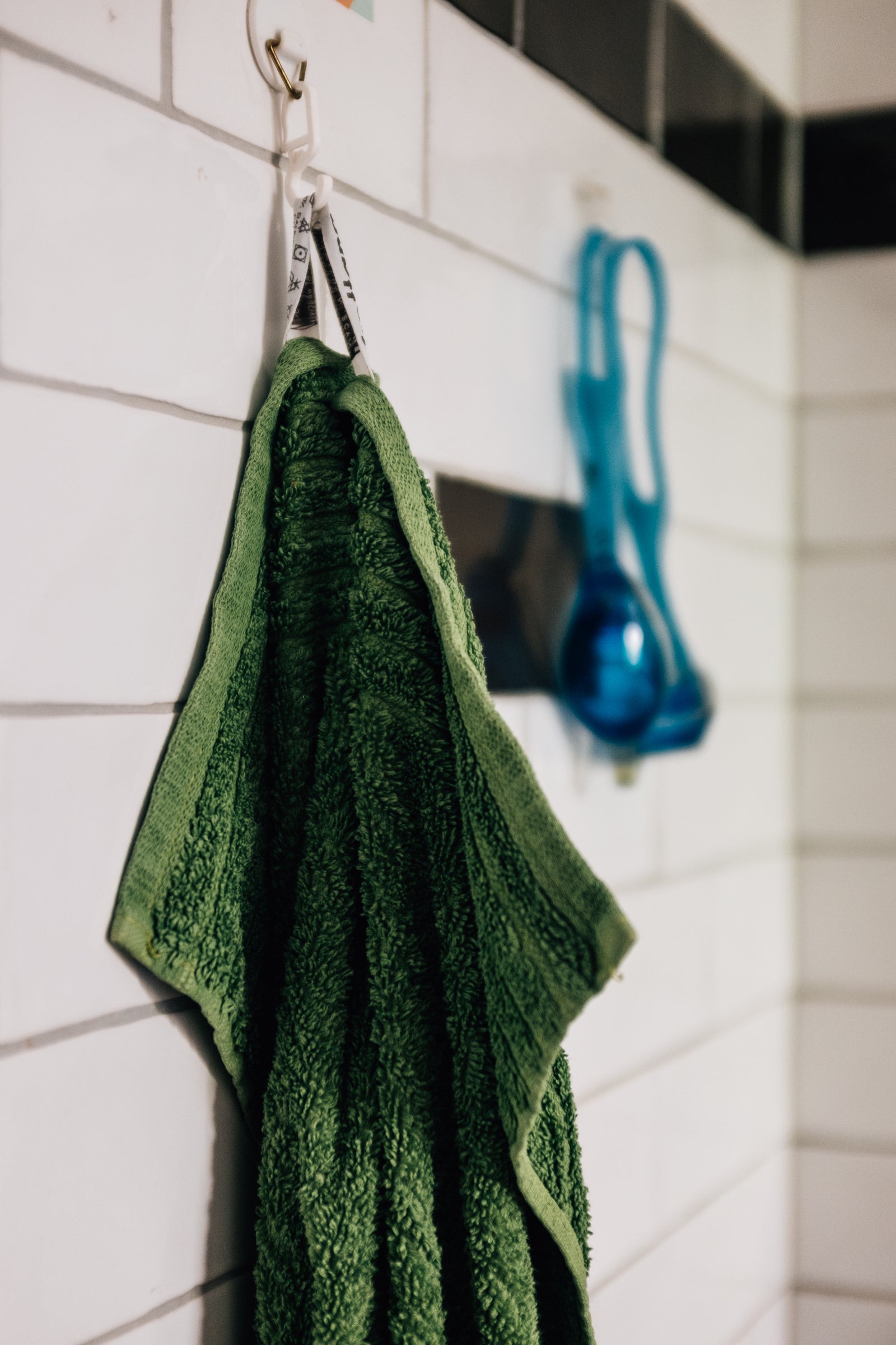 Hand towel hanging against a tiled wall